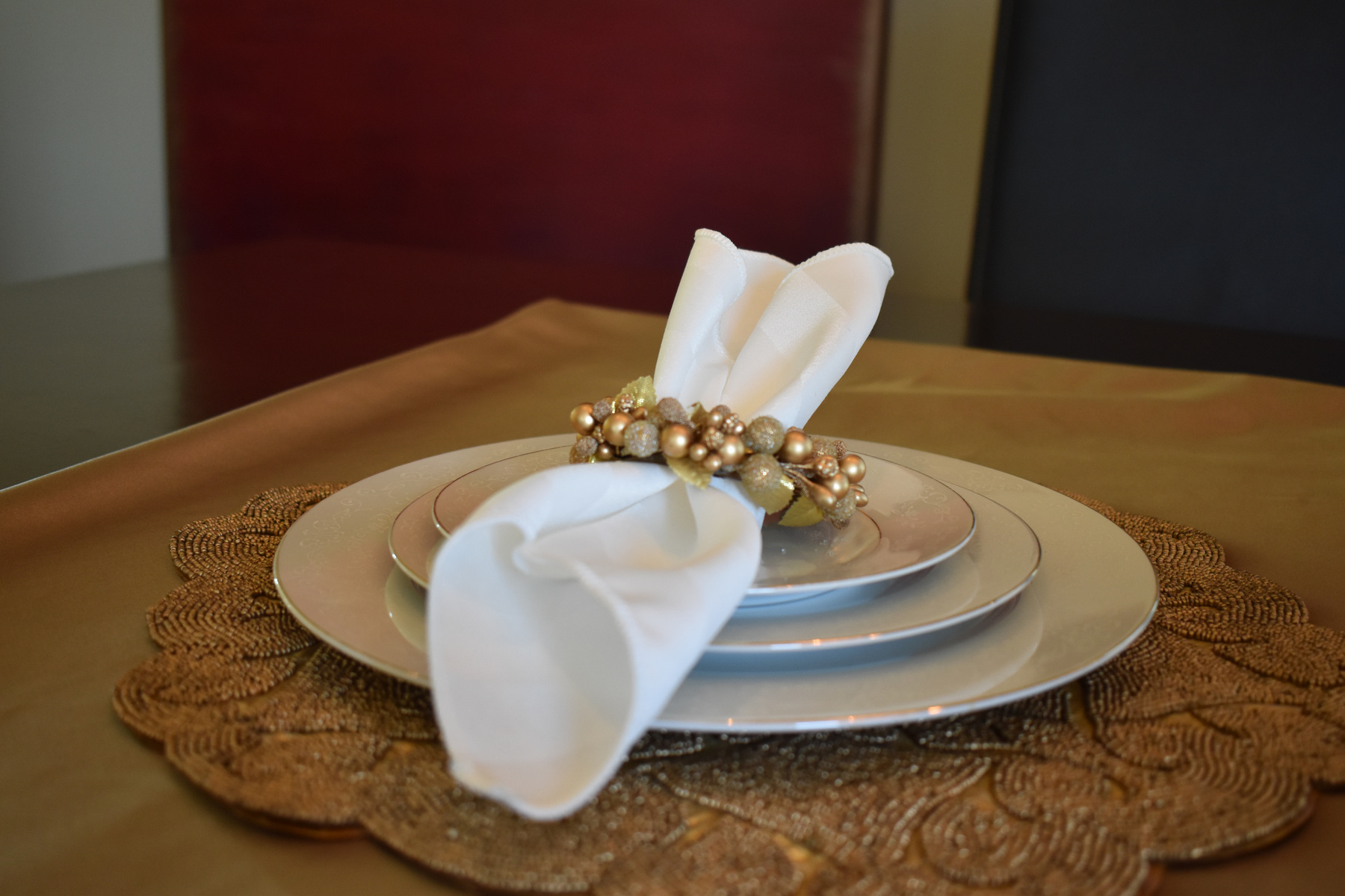 White event napkin arranged with a decorative gold ring and formal place setting